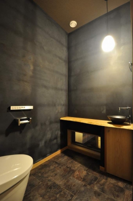 黒壁に白木の造作カウンターがアクセントになっているトイレ 株式会社TAKATA建築の施工事例 巨大な壁面アートのある家