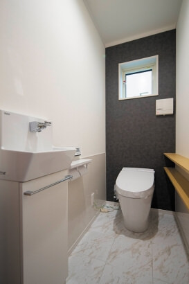 トイレに細い棚を2段、腰壁は掃除しやすいパネルに。 株式会社ハザマ住建の施工事例 木のぬくもりと自然の明るさも ふんだんに取り込んだ楽しい家 thumbnail