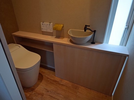 収納と手洗いカウンターを備えたトイレ 有限会社 吉田建築の施工事例 個性が光る、家事がしやすい住まい thumbnail