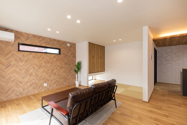 リビング 株式会社ホームライフの施工事例 ヘリンボーンの壁が映えるモダンな空間。木×白×黒の洗練デザインが魅力