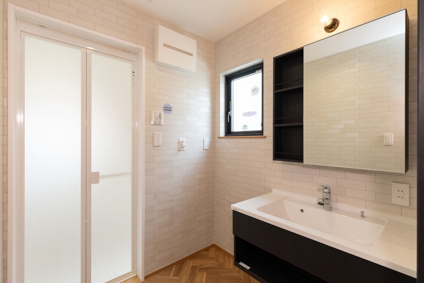 洗面台 株式会社ホームライフの施工事例 ヘリンボーンの壁が映えるモダンな空間。木×白×黒の洗練デザインが魅力