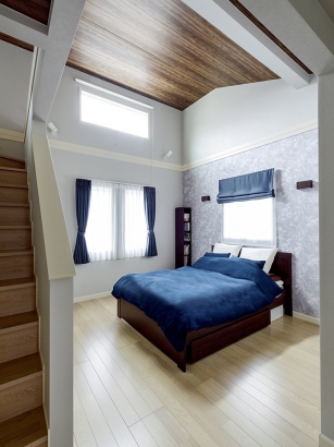 寝室は屋根形状を生かした勾配天井 三井ホーム株式会社の施工事例 硬質な素材と木の温もりが調和した家。